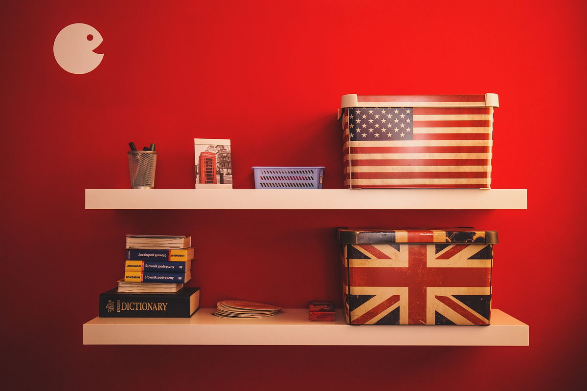 English dictionaries on book shelf and boxes with US and GB flag